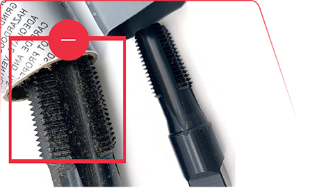 Close-up of a metal tap tool with a red box highlighting surface debris and wear on the threaded section.